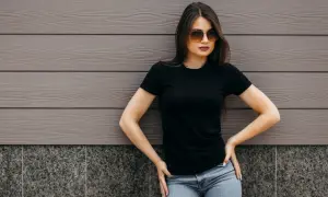 Kobieta w czarnej koszulce i jeansach, idealny przykład, jakie spodnie do czarnej koszuli damskiej pasują.